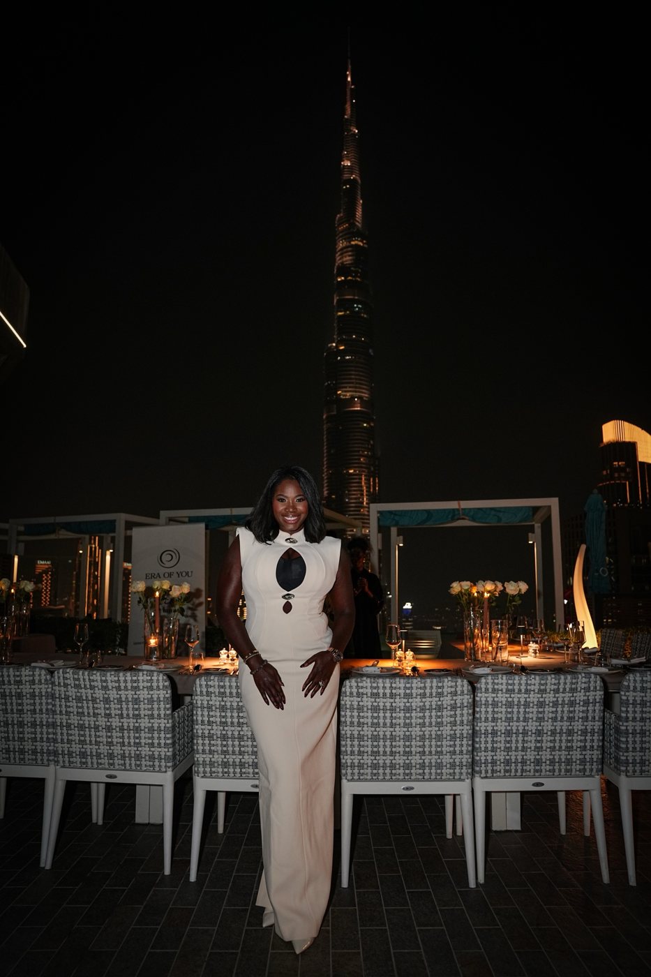 Ellen Mannaert in a cream fitted gown in front of the Burj Khalifa at an Era Of You evening